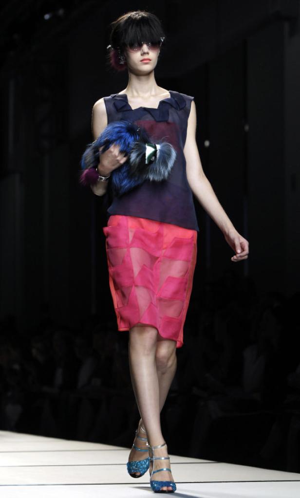 Ein Model präsentiert ein Outfit mit Pelzaccessoire auf dem Laufsteg.