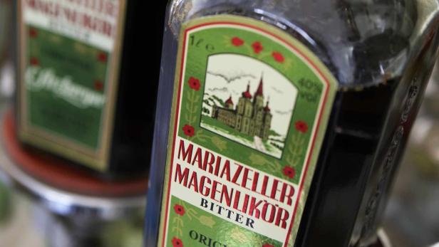 Eine Flasche Mariazeller Magenlikör Bitter mit einem Bild von Stift Mariazell auf dem Etikett.