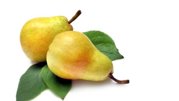 Zwei gelbe Birnen liegen auf grünen Blättern.