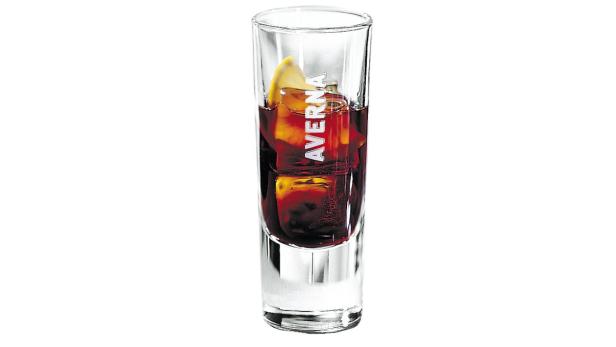 Ein Glas Averna mit Eiswürfeln und einer Zitronenscheibe.