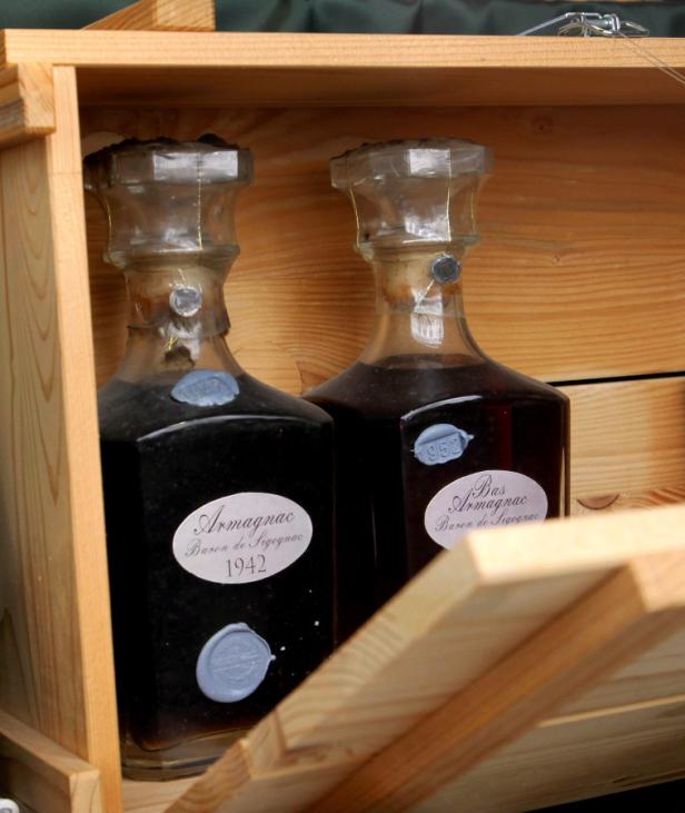 Zwei Flaschen Armagnac Baron de Sigognac in einer Holzkiste.