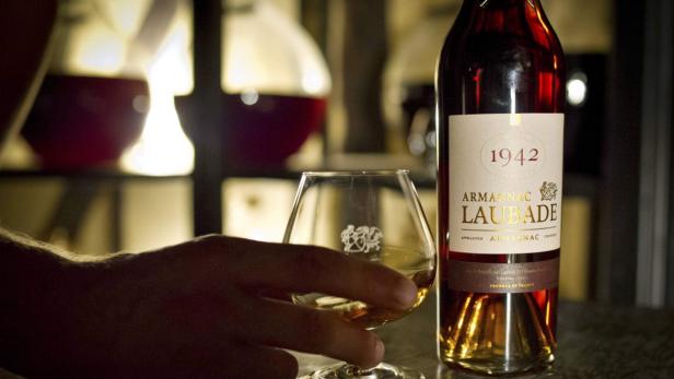 Ein Glas und eine Flasche Armagnac Laubade von 1942 stehen auf einem Tisch.