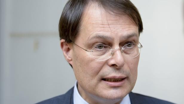 Ein Mann mit Brille und dunklen Haaren blickt in die Ferne.