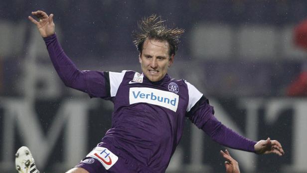 Ein Fußballspieler in lila Trikot springt während eines Spiels in die Luft.