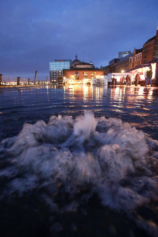 Ein Springbrunnen sprudelt im abendlichen Hamburg.