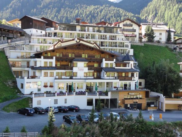 Das Hotel Fliana liegt in einer Berglandschaft mit bewaldeten Hängen.