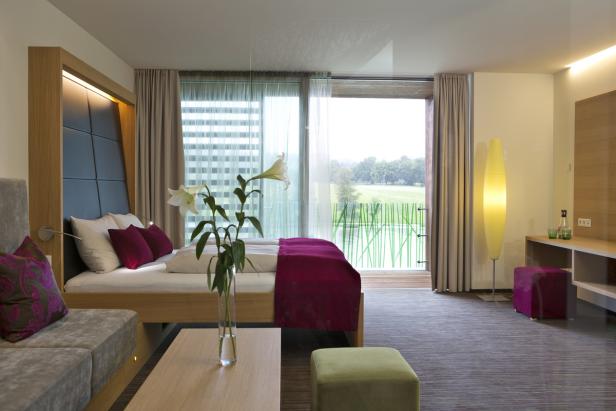 Ein modernes Hotelzimmer mit Blick auf eine grüne Landschaft.