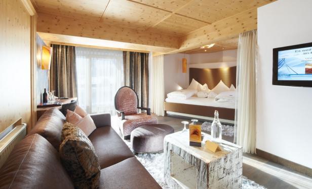 Ein luxuriöses Hotelzimmer mit Wohnbereich und Schlafbereich.