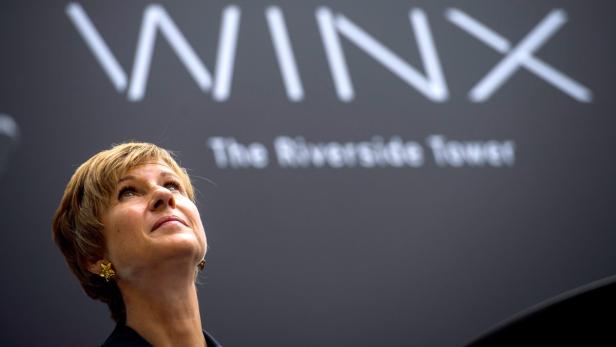 Eine Frau blickt auf das „Winx“-Logo des Riverside Tower.