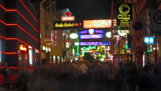 Die Große Freiheit in Hamburg St. Pauli bei Nacht mit vielen Leuchtreklamen und Menschen.
