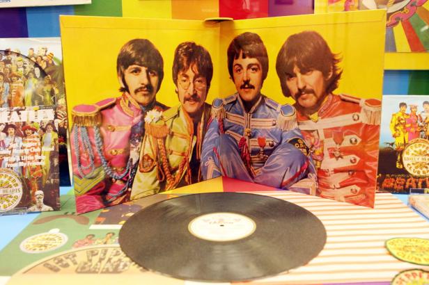 Das Album „Sgt. Pepper’s Lonely Hearts Club Band“ der Beatles mit einer Schallplatte im Vordergrund.