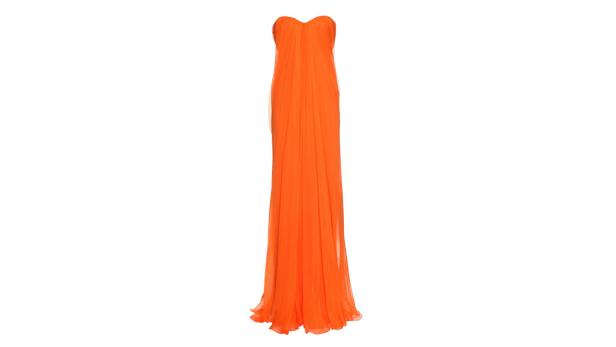 Ein trägerloses, orangefarbenes Abendkleid vor einem weißen Hintergrund.