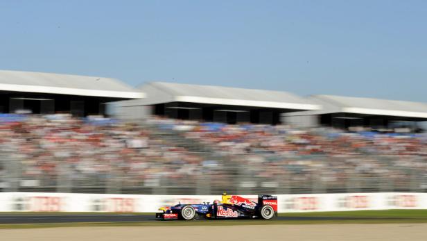 Ein Formel-1-Rennwagen rast an einer Tribüne voller Zuschauer vorbei.