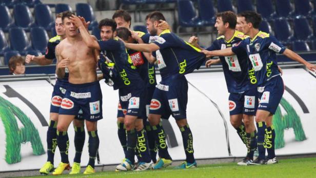 Eine Gruppe Fußballspieler feiert ein Tor.
