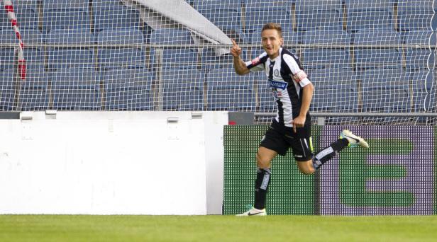 Ein Fußballspieler jubelt auf dem Spielfeld.