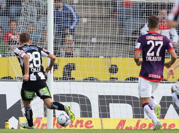 Ein Fußballspieler schießt den Ball ins Tor.