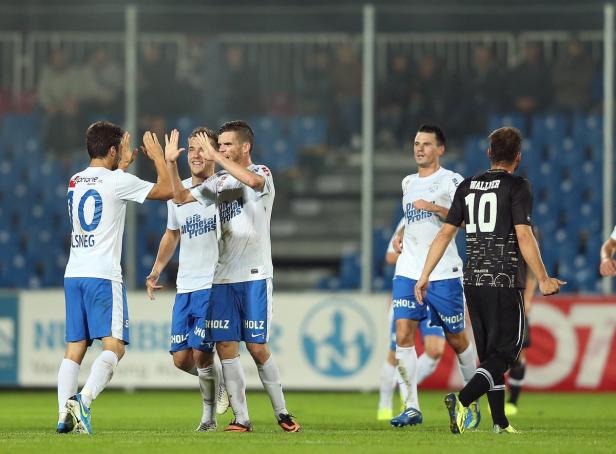 Fußballspieler feiern gemeinsam auf dem Spielfeld.