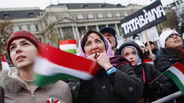 Menschen demonstrieren mit ungarischen Flaggen und einem Schild mit der Aufschrift „Tatabánya“.