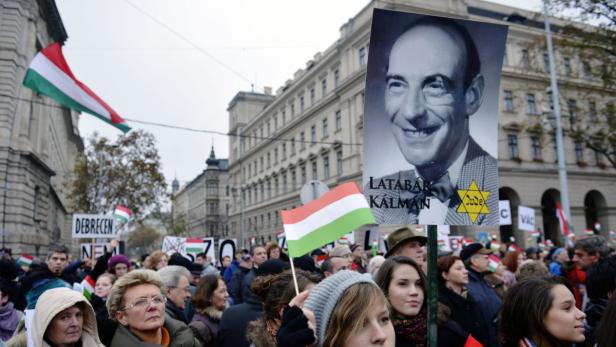 Eine Menschenmenge demonstriert mit ungarischen Flaggen und einem Porträt von Latabár Kálmán.
