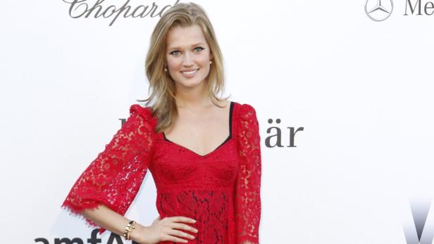 Toni Garrn trägt ein rotes Spitzenkleid auf einer Veranstaltung.