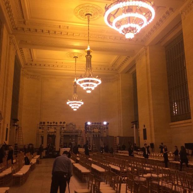 Ein großer Saal mit goldenen Kronleuchtern wird für eine Veranstaltung vorbereitet.