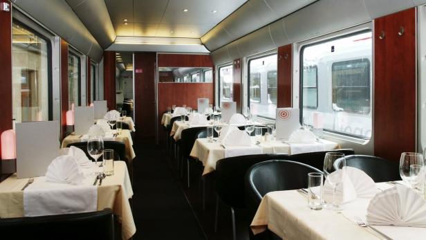 Ein Speisewagen mit gedeckten Tischen in einem Zug.