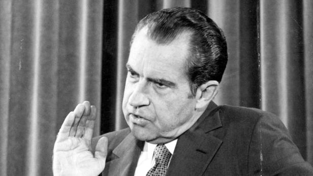 Richard Nixon während einer Rede mit erhobener Hand.