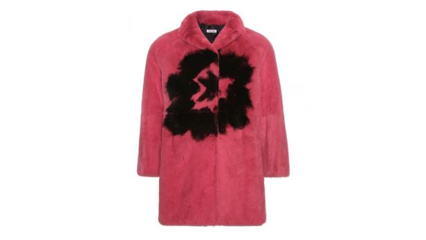 Ein rosafarbener Mantel mit einem großen, schwarzen Muster auf der Vorderseite.