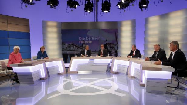 Mehrere Politiker sitzen in der „Berliner Runde“ an Tischen.