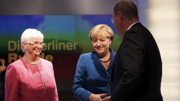 Angela Merkel im Gespräch mit zwei weiteren Personen.