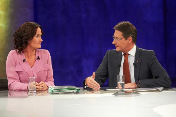 Eine Frau und ein Mann sitzen an einem Tisch und diskutieren.