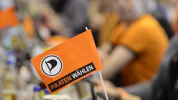 Eine orangefarbene Flagge der Piratenpartei mit der Aufschrift „Piraten wählen“.