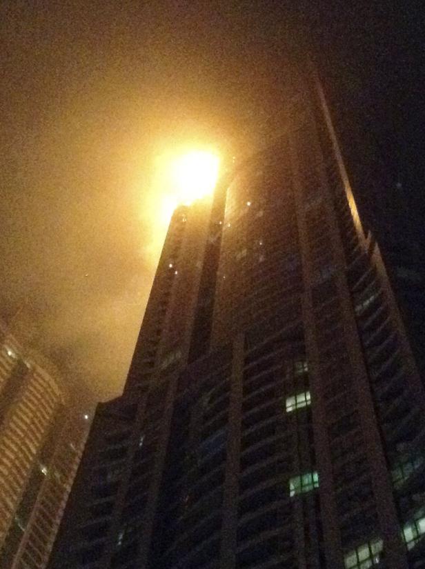 Ein Hochhaus erstrahlt nachts im goldenen Licht.