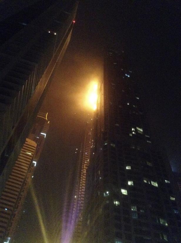 Ein Hochhaus steht nachts in Flammen.