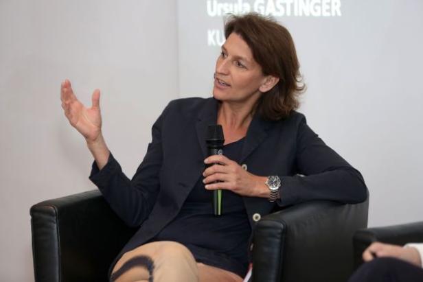 Ursula Gastinger sitzt in einem Sessel und spricht in ein Mikrofon.