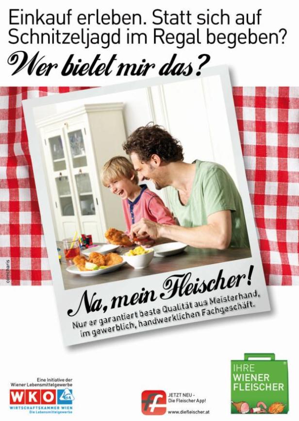 Ein Vater und sein Sohn lachen beim Essen von Brathähnchen am Tisch.