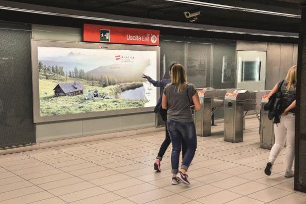 In einer U-Bahn-Station wirbt eine Anzeige für Urlaub in Österreich.