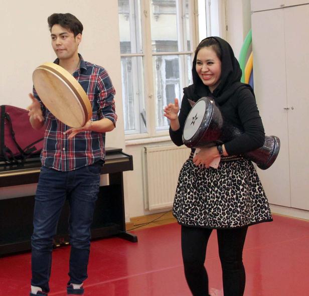 Ein Mann und eine Frau spielen auf einer Rahmentrommel und einer Darbuka.