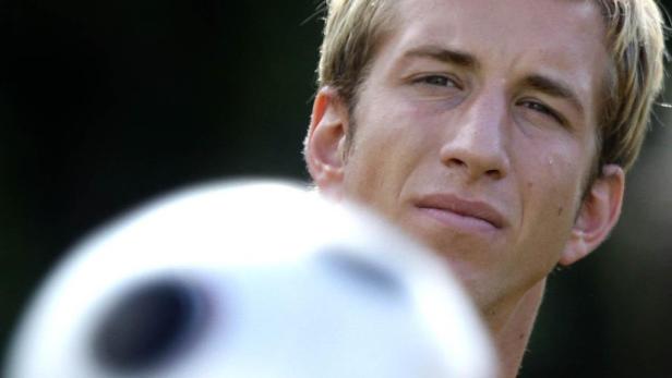 Ein Mann mit blonden Haaren und einem Fußball im Vordergrund.