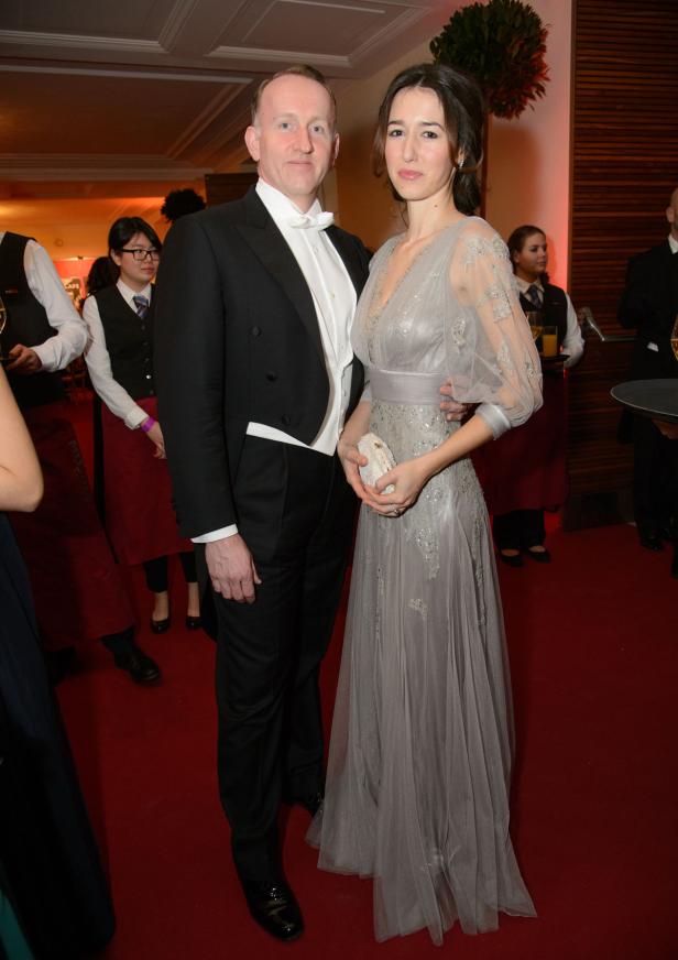 Ein Mann im Frack und eine Frau in einem grauen Abendkleid posieren für ein Foto.
