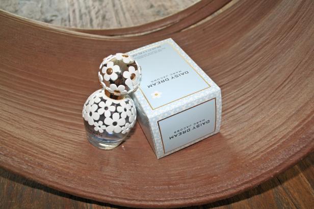 Ein Flakon und die Verpackung von „Daisy Dream“ von Marc Jacobs auf einer Holzoberfläche.