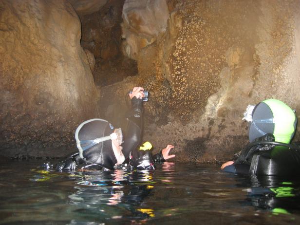 Zwei Taucher erkunden eine Unterwasserhöhle.