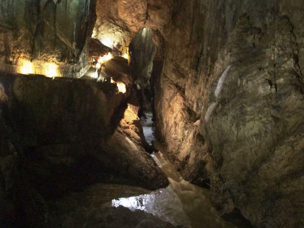 Eine Schlucht mit einem Fluss und einem beleuchteten Weg für Besucher.