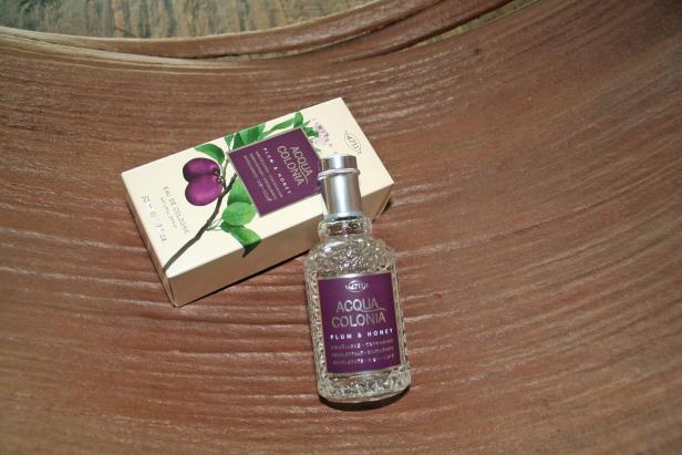 Eine Flasche und eine Schachtel „Acqua Colonia Plum & Honey“ auf einer Holzoberfläche.
