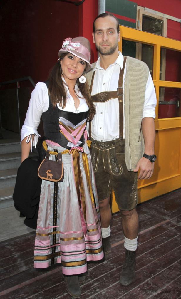 Ein Paar in Tracht posiert vor einem Gebäude.