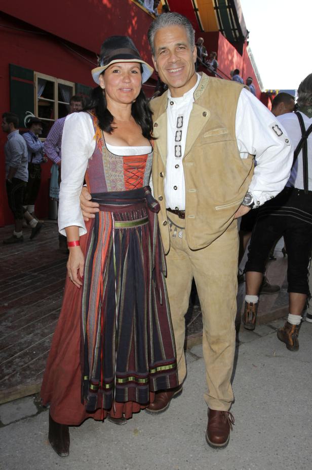 Ein Paar in Tracht vor einem roten Gebäude.