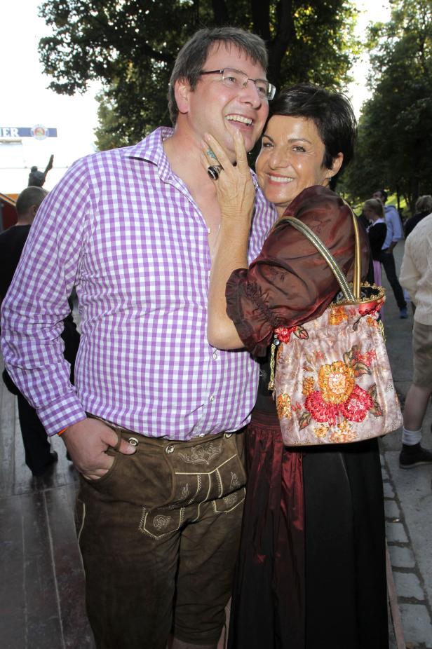 Ein Mann in Lederhosen und ein Frau im Dirndl lächeln in die Kamera.