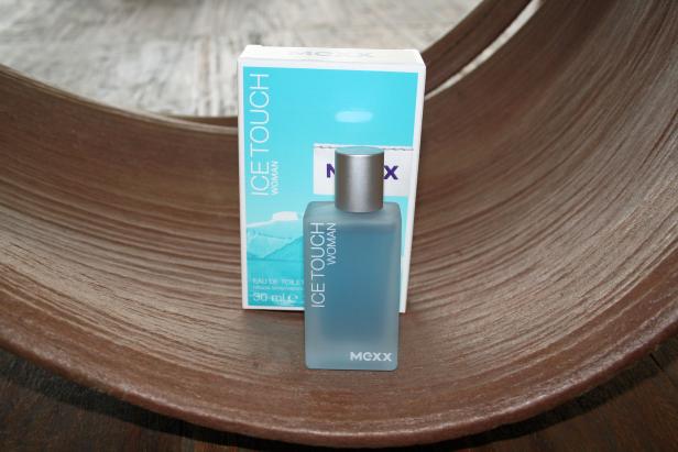 Ein Flakon „Ice Touch Woman“ von Mexx steht vor der passenden Verpackung.