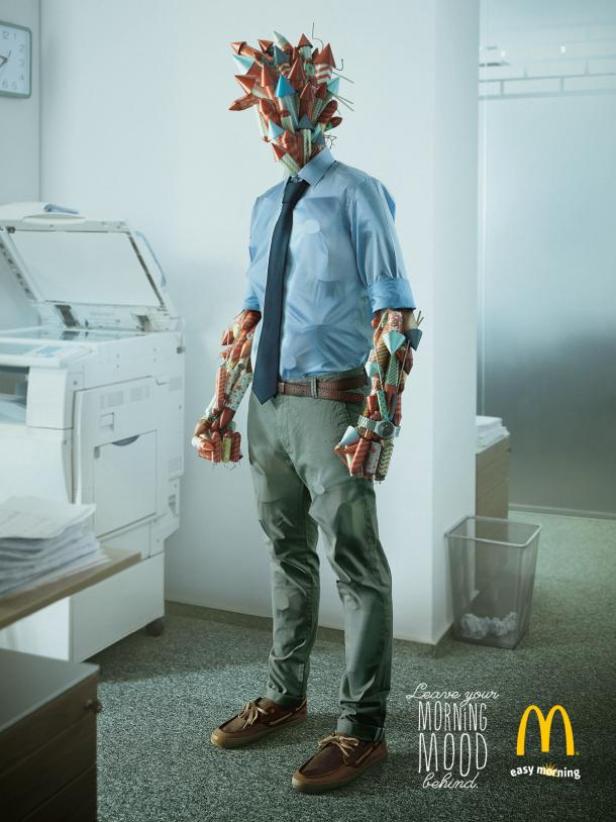 Ein Mann im Büro, dessen Kopf und Arme mit Frühstücksprodukten von McDonald's bedeckt sind.