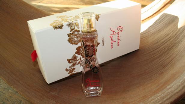 Eine Flasche Christina Aguilera Woman Eau de Parfum vor einer passenden Schachtel.